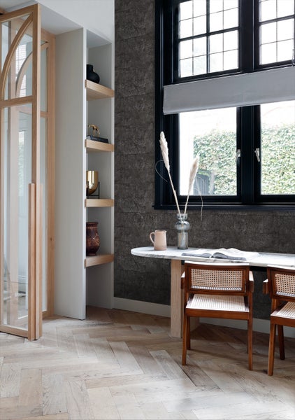 Innenraumszene mit einem Schreibtisch vor einem Fenster und einem Regal.