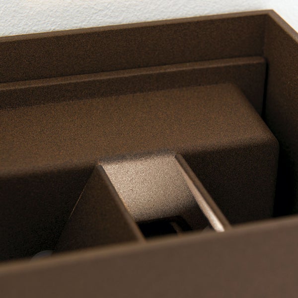 Nahaufnahme einer Wandleuchte aus strukturiertem Metall mit rechteckigen Formen.