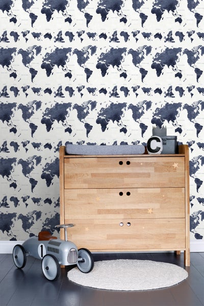 Kinderzimmer mit Kommode, Spielzeugauto, Teppich und Weltkarten-Tapete