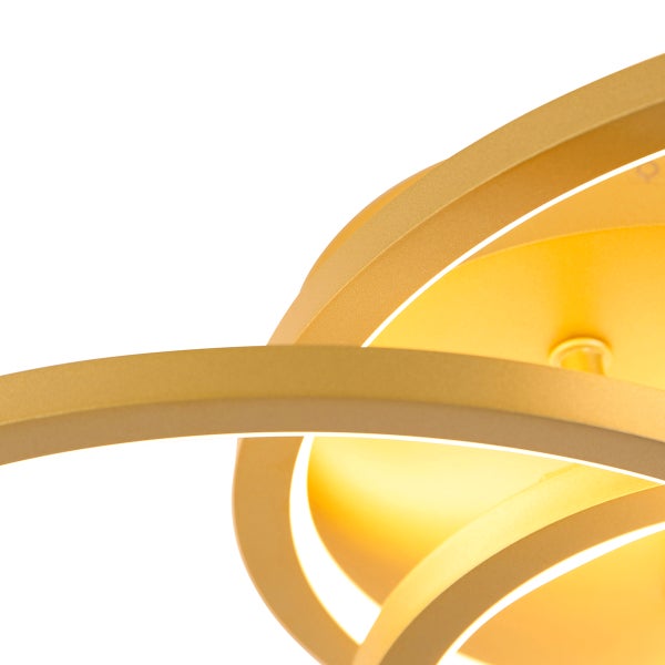 Detailaufnahme einer Deckenleuchte mit verschlungenen goldenen Ringen