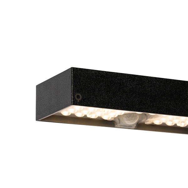 Nahaufnahme einer schwarzen rechteckigen LED Außenwandleuchte mit Bewegungsmelder und warmweißem Licht.