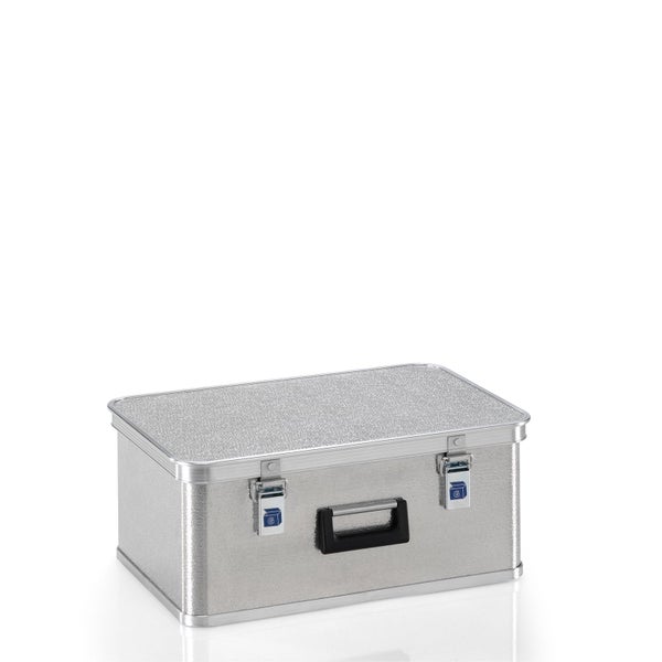 Olivenbaum Olea europaea mit knorrigem Stamm und silbrig-grünen Blättern im Pflanztopf, helle Außenanlage eines Gartenmarktes mit Erdsäcken.