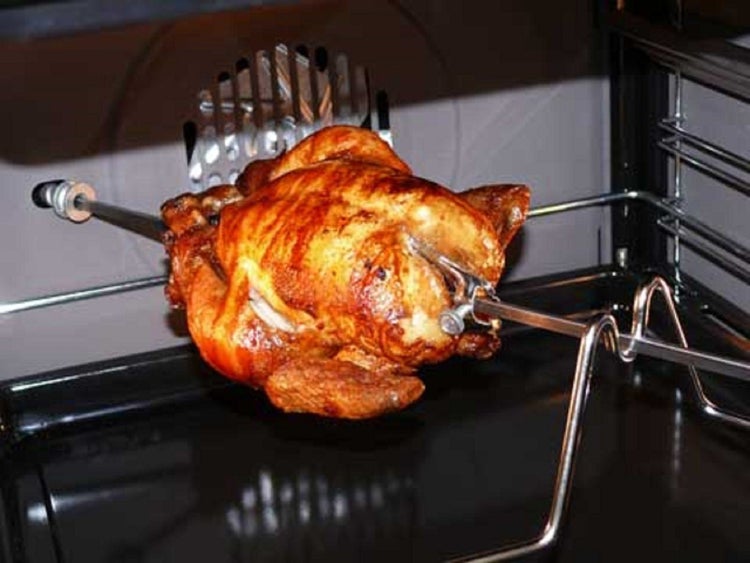 Gebratenes Hähnchen auf einem Bratspieß im Backofen