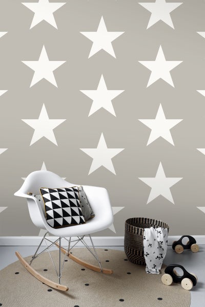 Szene mit Sternentapete, Schaukelstuhl, Kissen, rundem Teppich, Korb und Spielzeugautos.