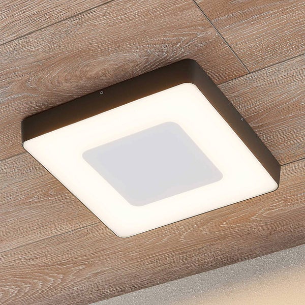 Moderne quadratische LED-Deckenleuchte mit dunklem Rahmen und weißem Diffusor, montiert an einer Holzdecke.