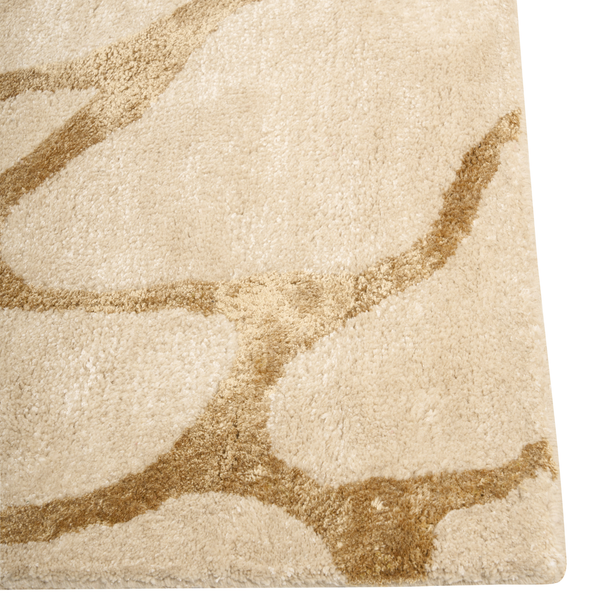 Nahaufnahme eines beigen Hochflor-Teppichs mit einem braunen, wellenförmigen Muster.
