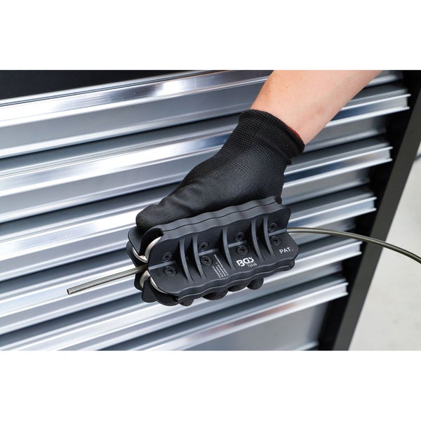 Rohrbiegevorrichtung mit Hand und Handschuh vor Werkzeugschrank