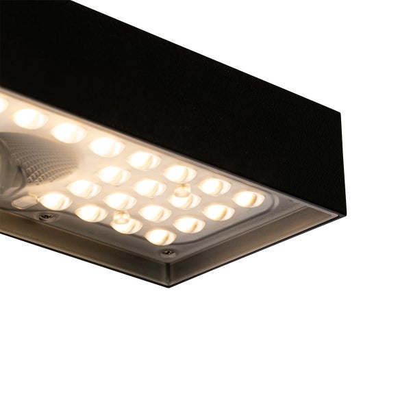 Nahaufnahme eines schwarzen LED-Strahlers aus Metall mit mehreren leuchtenden warmweißen LED-Punkten.