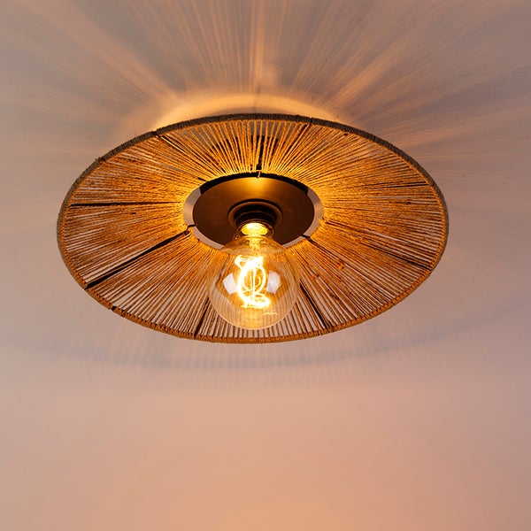 Runde Deckenleuchte mit Schirm aus Hanfseil und sichtbarem Filament-Leuchtmittel an der Decke.