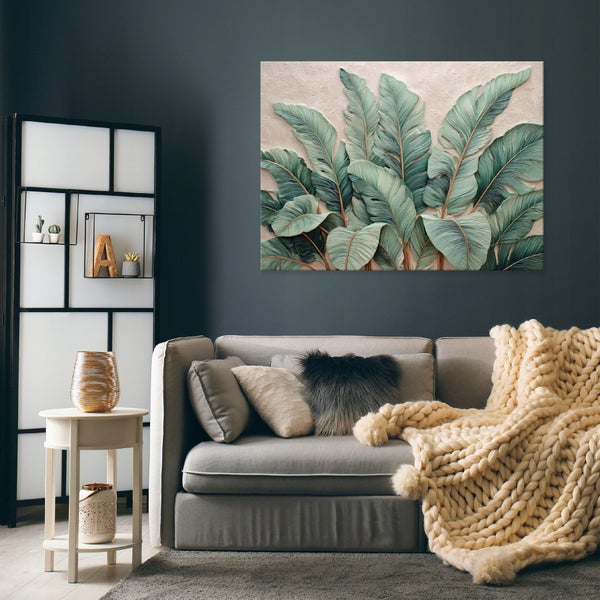 Wohnzimmer mit Sofa, Dekokissen, Decke, Tisch und Wandbild mit Pflanzenmotiven