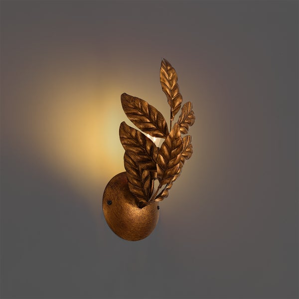 Goldfarbene Wandleuchte aus Metall mit dekorativen Blättern und antikem Finish.
