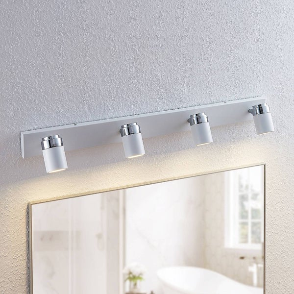 Eine Badezimmerleuchte mit vier Strahlern über einem Spiegel.