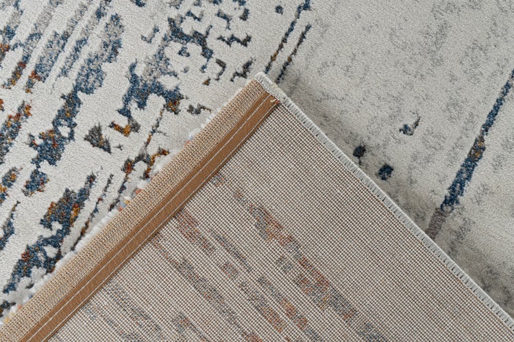 Nahaufnahme eines Teppichs mit Vintage-Muster und umgeknickter Ecke, die die gewebte Rückseite und die Kantenverarbeitung zeigt.