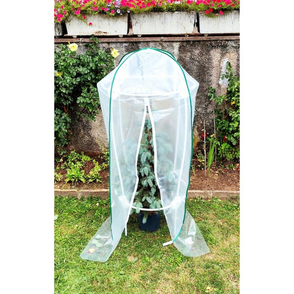 Pflanzenschutzhaube mit Reißverschluss über einer Pflanze im Garten