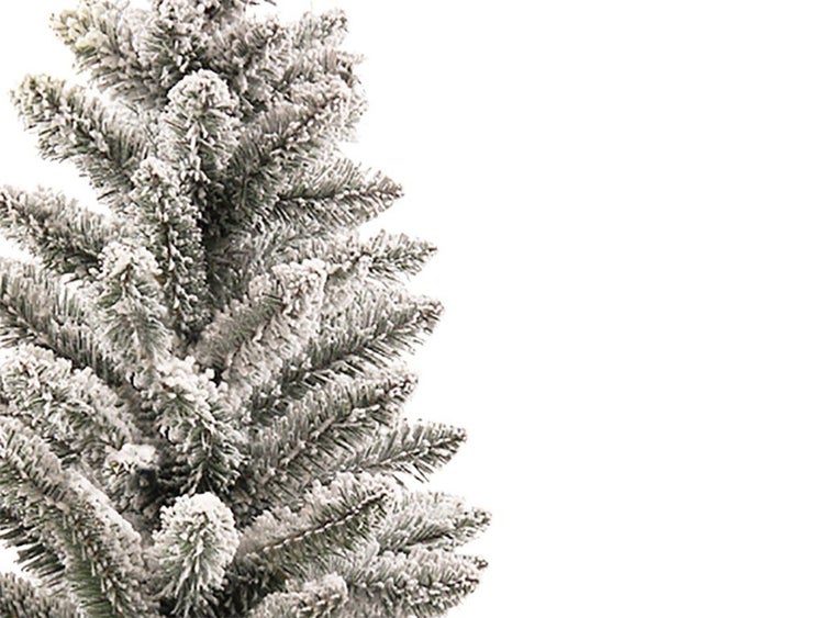 Künstlicher Weihnachtsbaum mit künstlichem Schnee auf den Zweigen für festliche Dekoration.