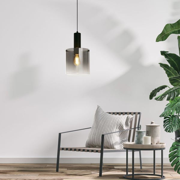 Szene mit Pendelleuchte, Sessel, Kissen, Beistelltisch und Zimmerpflanze für eine helle, freundliche Atmosphäre.