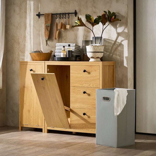 Badezimmer mit Holzkommode mit Wäschekippe, Wäschekorb und Dekorationsgegenständen