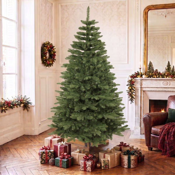 Großer, künstlicher Weihnachtsbaum in einem festlich dekorierten Wohnzimmer mit Weihnachtsgeschenken unter dem Baum.