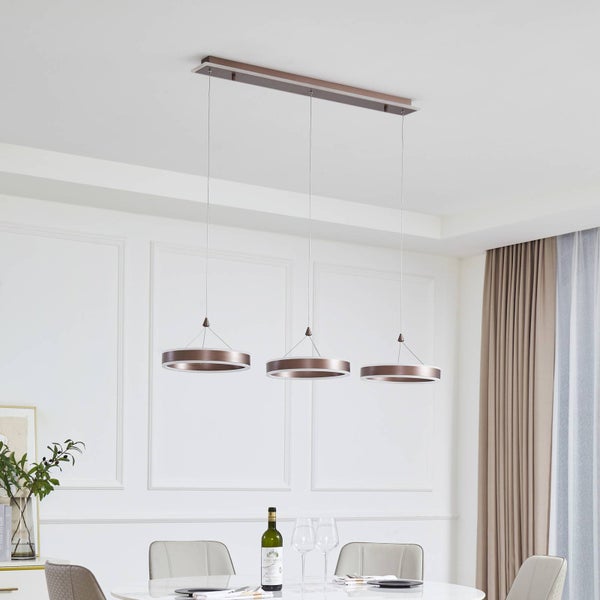 Moderne Pendelleuchte mit drei ringförmigen LED-Elementen über einem Esstisch in einem hellen, eleganten Wohnbereich.