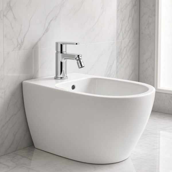 Bidet mit Armatur in einem modernen Badezimmer mit Marmorfliesen an der Wand.