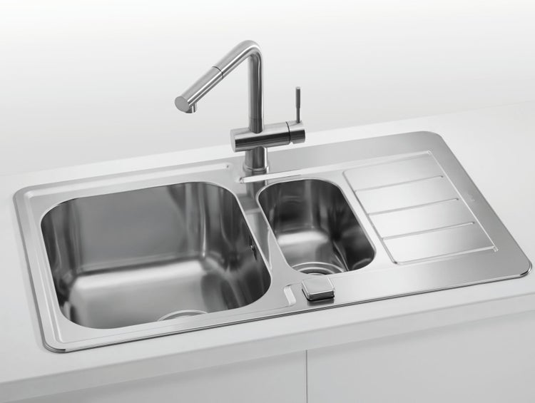 Edelstahl Einbauspüle mit zwei Becken und Abtropffläche sowie Küchenarmatur auf einer Arbeitsplatte montiert.