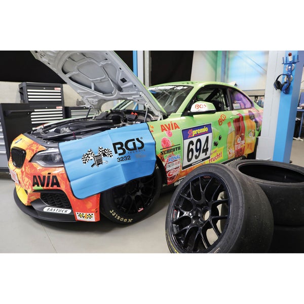Rennwagen in einer Werkstatt mit geöffneter Motorhaube und BGS technic Schutzblech