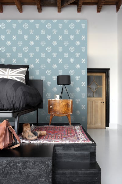 Schlafzimmer mit Bett, Nachttisch und gemusterter Tapete im College-Stil