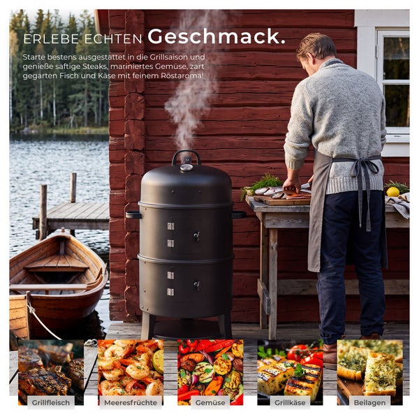 Mann bereitet Essen vor einem holzbefeuerten Räuchergrill auf einer Terrasse an einem See vor, umgeben von gegrillten Speisen wie Fleisch und Gemüse.