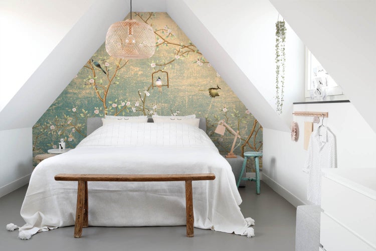 Schlafzimmer im Dachgeschoss mit floraler Tapete, Bett und Holzbänken