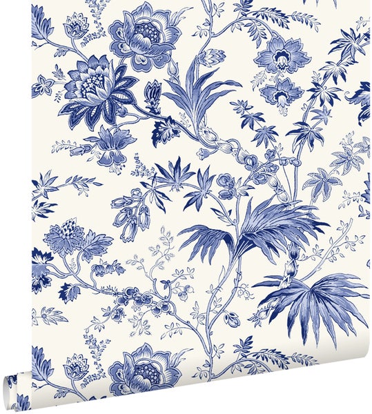 Tapete mit blauem Blumenmuster und Blättern auf hellem Hintergrund.