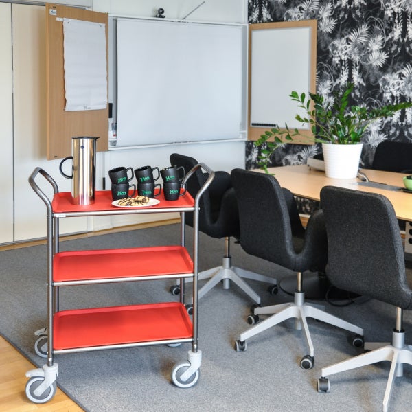 Servierwagen mit drei Ablagen, Kaffeekanne, Tassen und Keksen in Büroumgebung