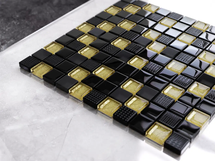 Glasmosaik Fliese mit quadratischen Steinchen in Schwarz und Gold, matte, glänzende und strukturierte Oberflächen.
