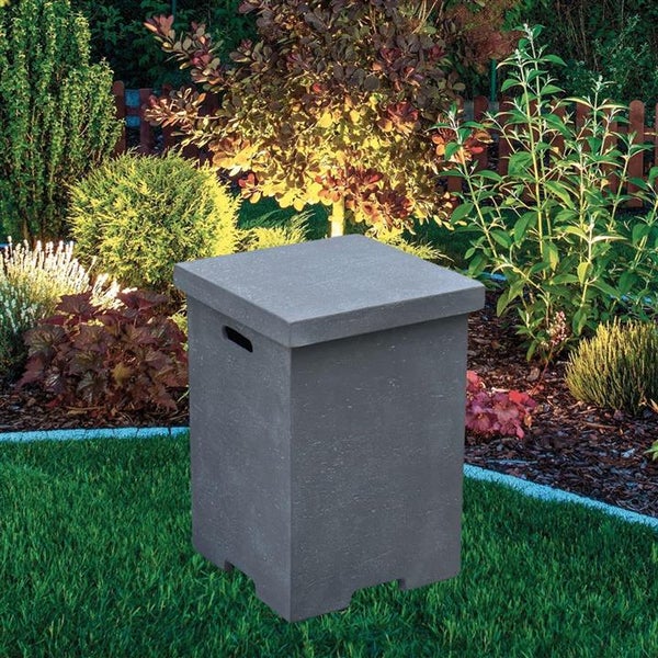 Quadratische Gasflaschenverkleidung in Betonoptik mit Deckel und seitlichem Griff in einem bepflanzten Garten auf einer Rasenfläche.