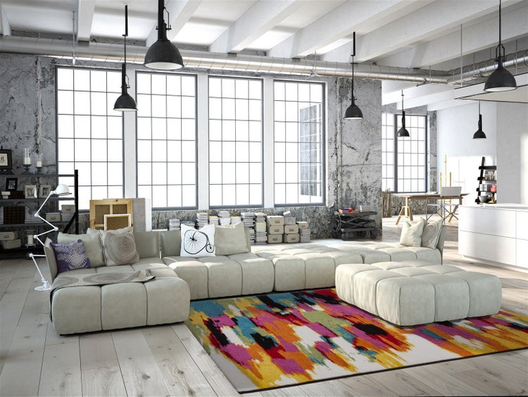 Modernes Wohnzimmer im Loftstil mit großem modularen Sofa, bunten Teppich und hohen Fenstern im Industriestil in einem hellen, offenen Raum.