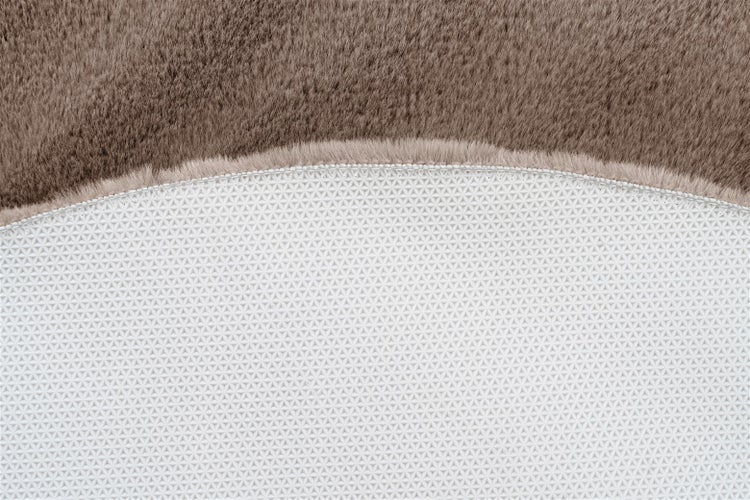 Nahaufnahme eines braunen Kunstfellteppichs mit rutschfester Rückseite.