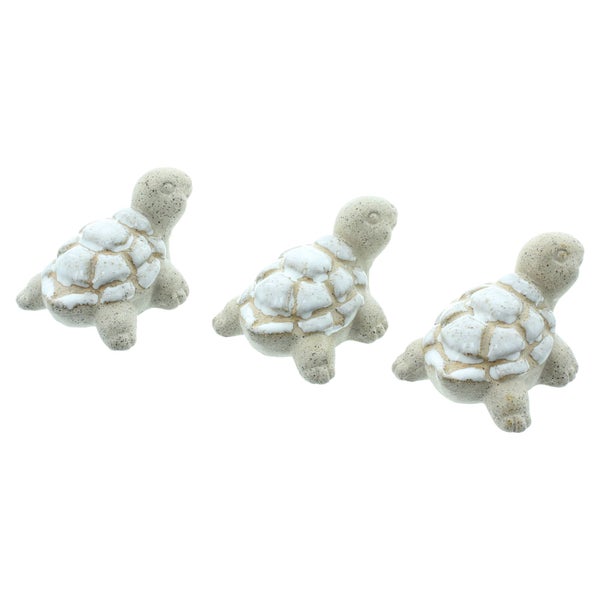 Drei kleine dekorative Schildkröten aus Stein mit weiß glasierten Panzern.