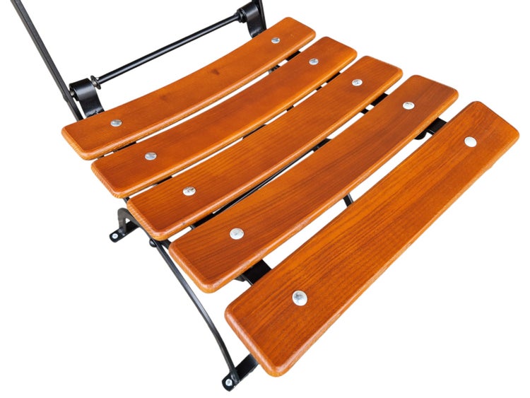 Sitzfläche eines Klappstuhls mit fünf Holzlatten und schwarzem Metallgestell.