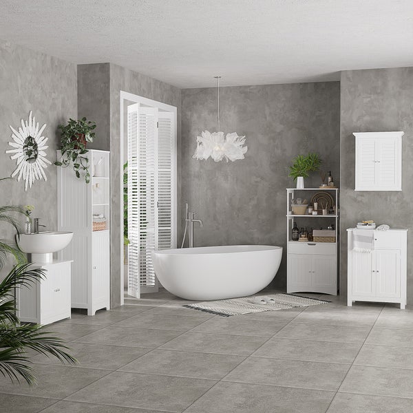 Modernes Badezimmer mit freistehender Badewanne, weißen Badmöbeln im Landhausstil, grauen Fliesen und dekorativen Pflanzen.