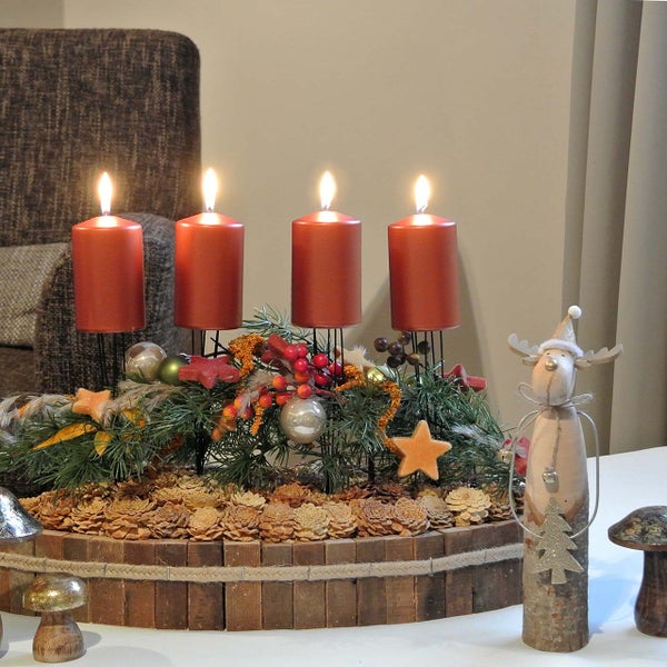 Dekorativer Adventskranz mit vier brennenden Kerzen, Tannenzweigen, Schmuckelementen und Holzdekoration
