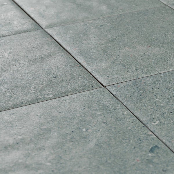 Quadratische Bodenfliesen mit Natursteinoptik in rustikalem Design und matter Oberflächenstruktur.