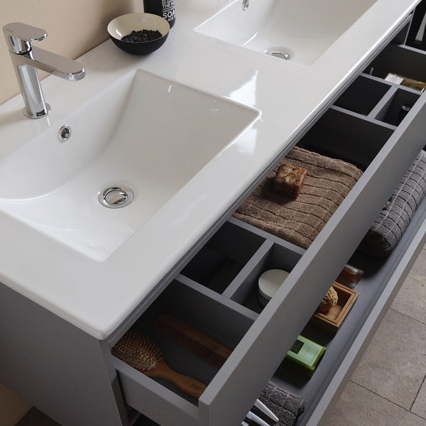 Badezimmerunterschrank mit Waschbecken, Armatur und offenen Schubladen mit Badutensilien