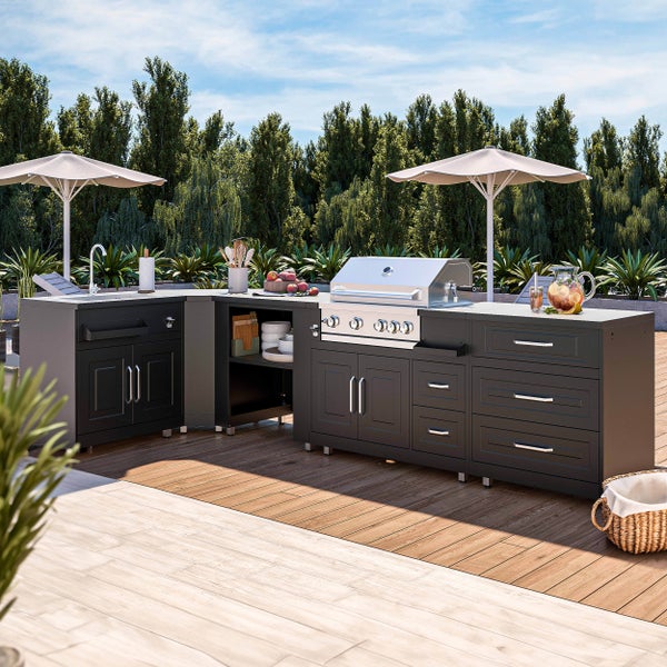 Moderne Außenküche mit Gasgrill aus Edelstahl, Spüle und Unterschränken auf einer Holzterrasse im Garten.