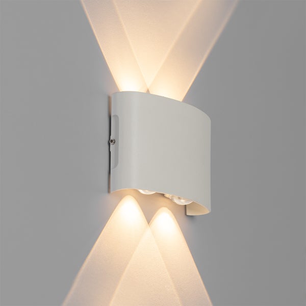 Moderne LED-Wandleuchte, Up-and-Down-Licht mit vier Lichtkegeln an einer Wand.