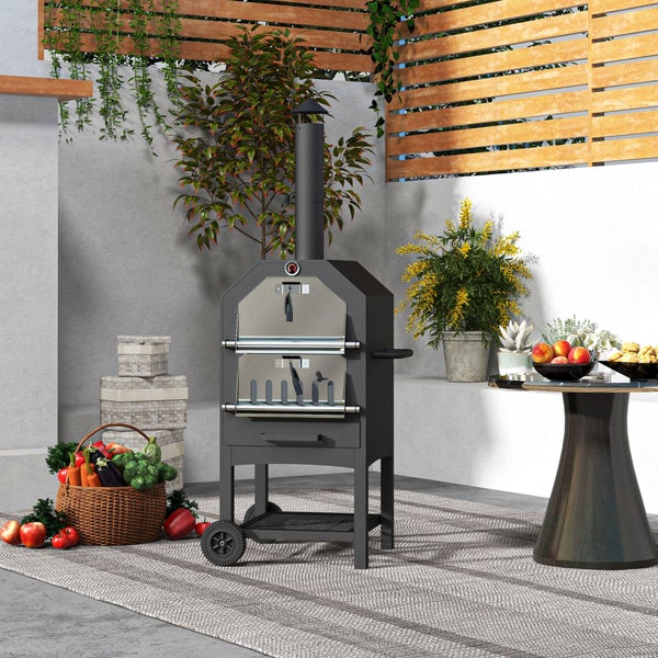 Schwarzer Pizzaofen auf Rädern in einem modern gestalteten Außenbereich mit Holzzaun, Pflanzen und Dekoration auf einer Terrasse.