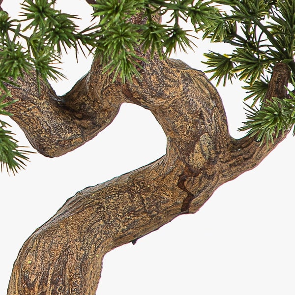 Nahaufnahme eines künstlichen Bonsai-Baums mit strukturiertem Stamm und grünen Nadeln.