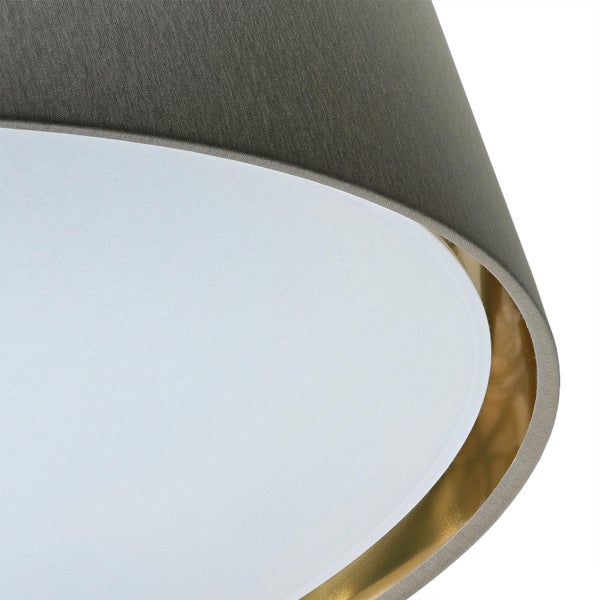 Detailansicht eines Lampenschirms mit Textiloberfläche und goldfarbener Innenseite