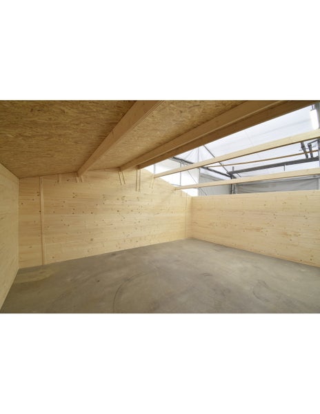 Innenansicht eines Gartenhauses aus Holz mit OSB-Dachplatten und Betonboden.