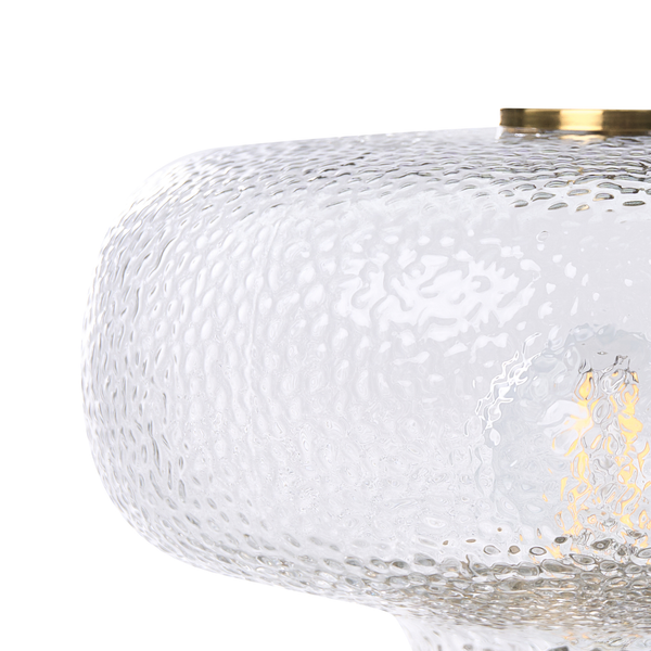 Detailansicht eines Lampenschirms aus strukturiertem Glas mit einer goldfarbenen Metallfassung.