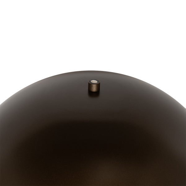 Detailaufnahme einer dunklen, gewölbten Metalloberfläche mit einem kleinen Knopf an der Oberseite.