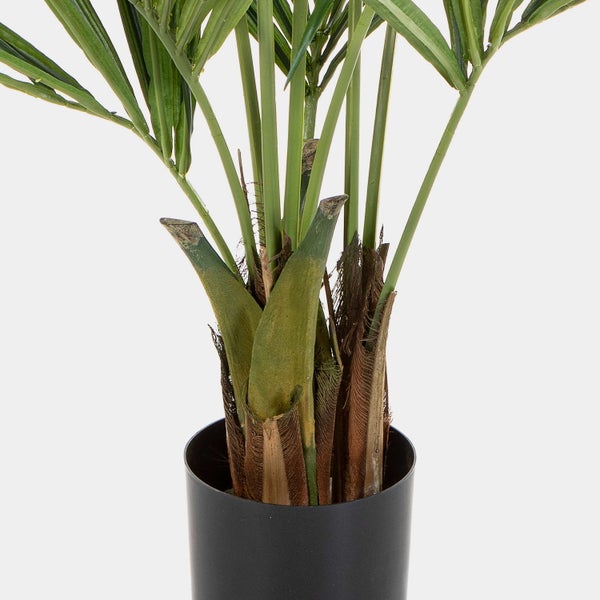 Detailaufnahme einer künstlichen Palme mit grünen Blättern und braunem Faserstamm in einem schwarzen Kunststofftopf.